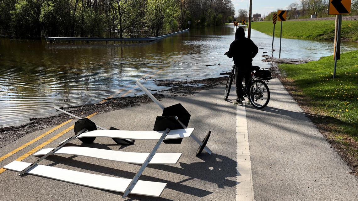 A cyclist takes a look at the flooding on Joseph J Schwab Road in Des Plaines, Ill., as rising waters from the Des Plaines River threaten the area on Saturday, April 18, 2026. (Chris Sweda/Chicago Tribune/TNS)