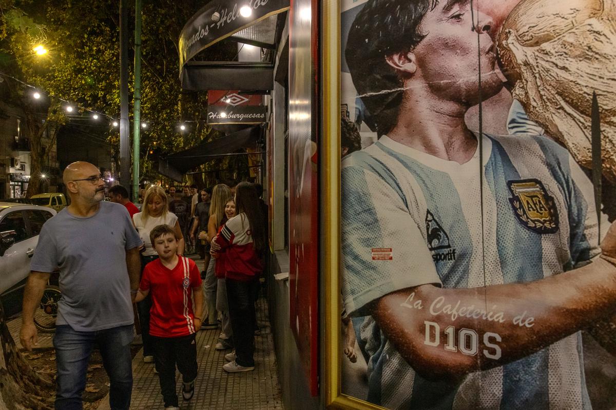 People walk past a mural depicting soccer legend Diego Maradona in Buenos Aires, Argentina, on April 18, 2026. In Maradona and Lionel Messi, Argentina has produced two of soccer's best players. (Sarah Pabst/The New York Times)