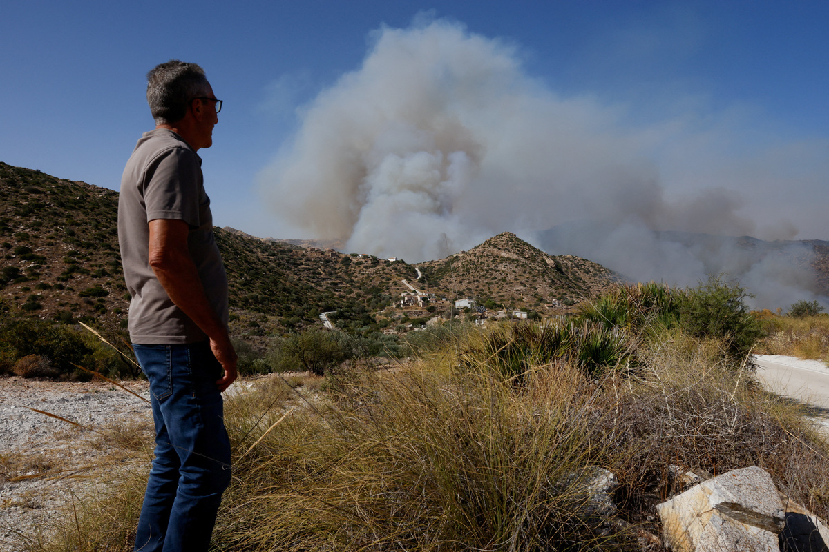 A local watches as smoke rises over the hills, amid deadly wildfires affecting Almeria province, in Sorbas, Almeria, Spain, July 10, 2026. REUTERS/Jon Nazca