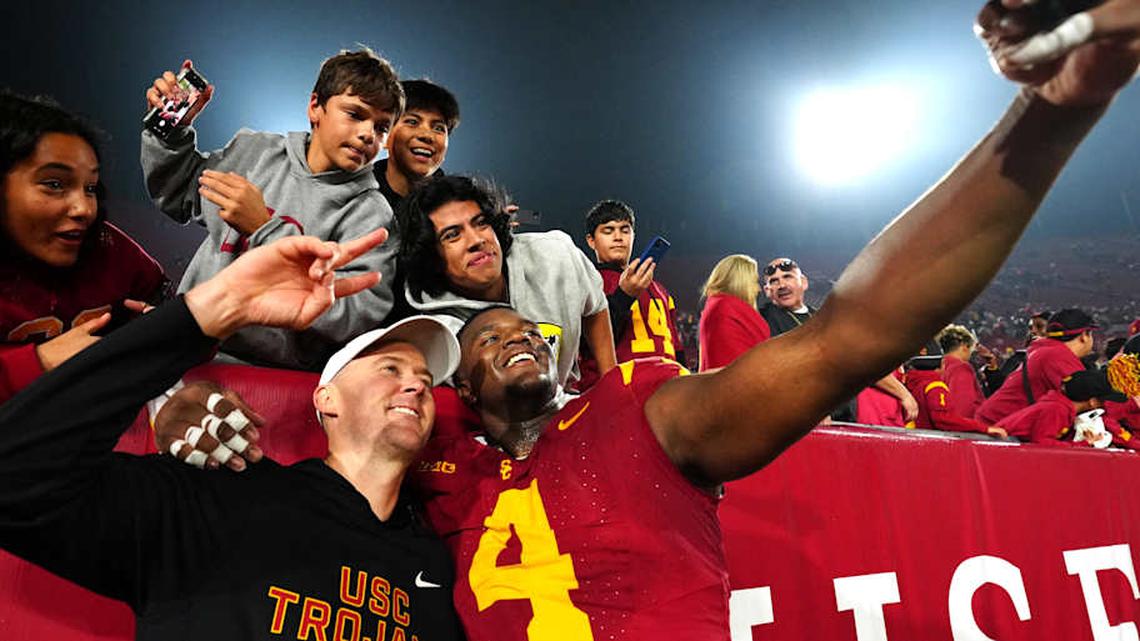  Nov 29, 2025; Los Angeles, California, USA; Southern California Trojans head coach Lincoln Riley (right) and defensive tackle Jahkeem Stewart (4) pose with fans after the game against the UCLA Bruins at United Airlines Field at Los Angeles Memorial Coliseum. Mandatory Credit: Kirby Lee-Imagn Images | Kirby Lee-Imagn Images 