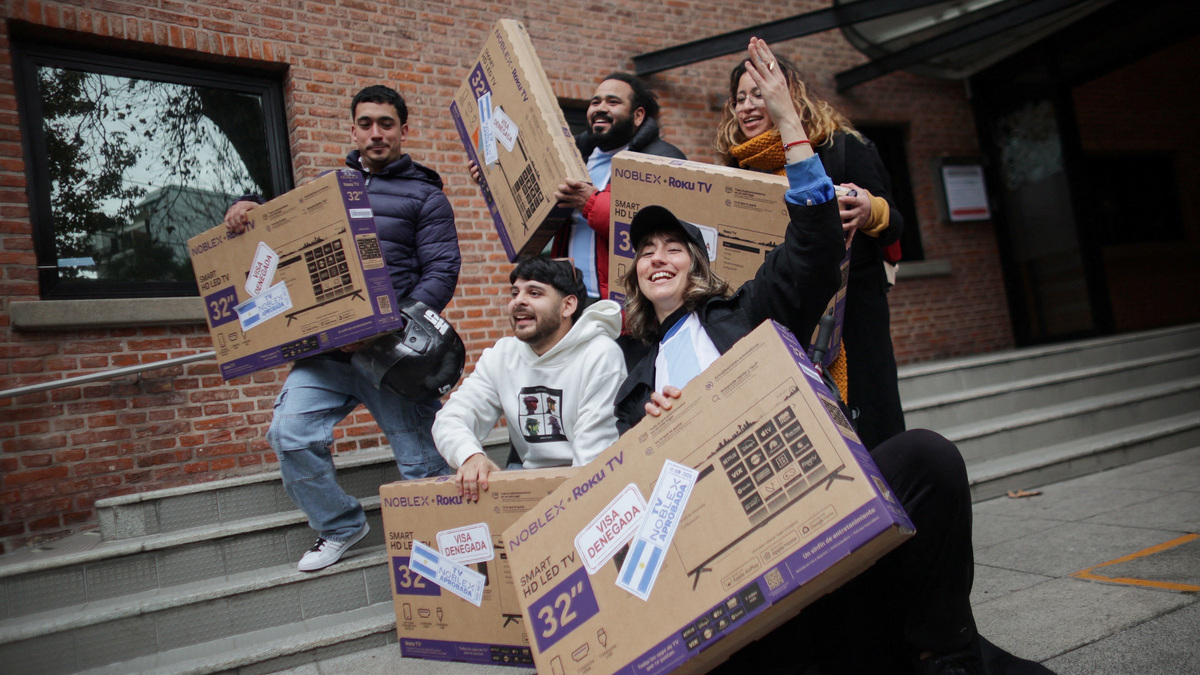 Un grupo de personas posa con los televisores que recibieron de regalo tras demostrar que sus visas a Estados Unidos fueron rechazadas, la condición impuesta por el fabricante de televisores Noblex para las primeras 100 personas que llegaran a sus oficinas en Buenos Aires, Argentina, el 10 de junio de 2026.