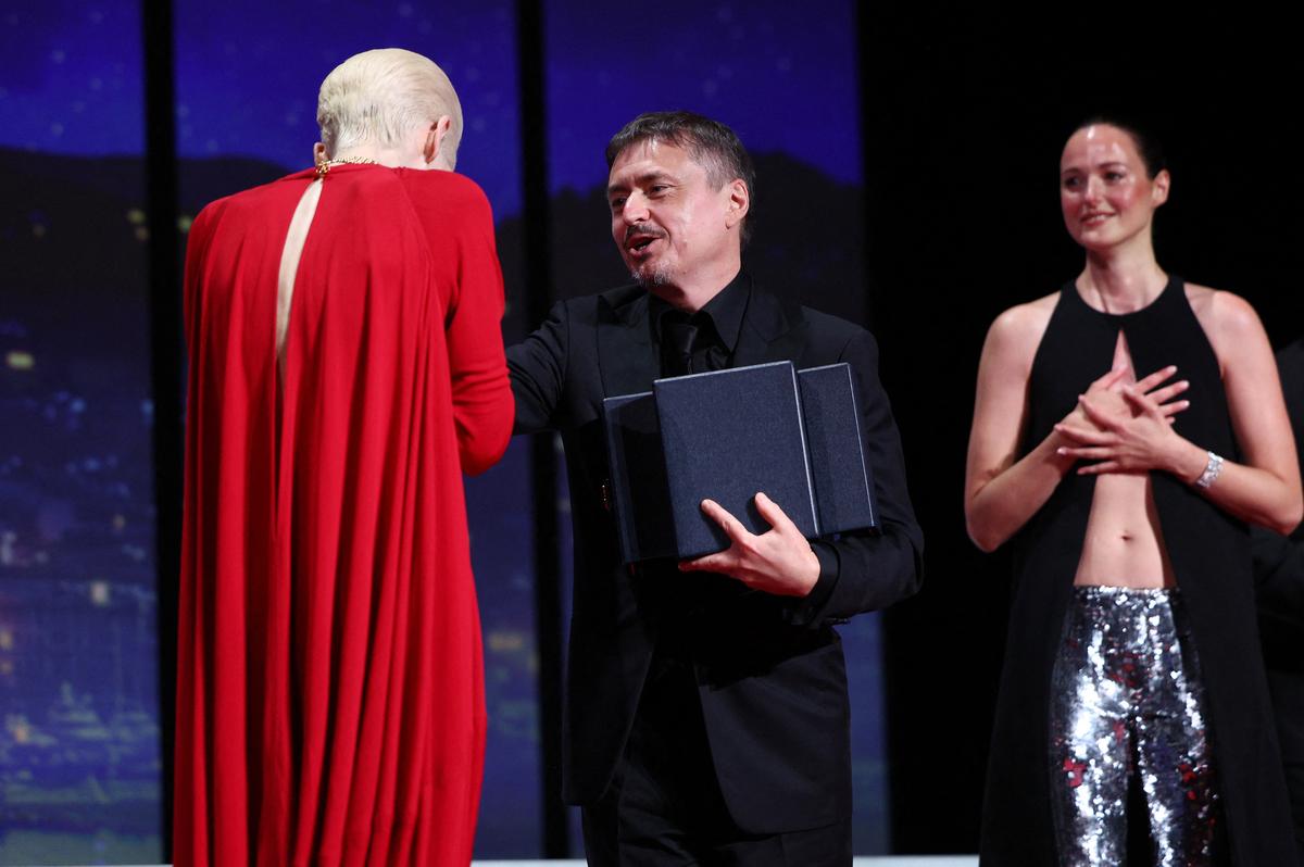 Cast member Renate Reinsve reacts as director Cristian Mungiu receives the Palme d'Or award for the film "Fjord" from Tilda Swinton during the closing ceremony of the 79th Cannes Film Festival in Cannes, France, May 23, 2026. REUTERS/Marko Djurica