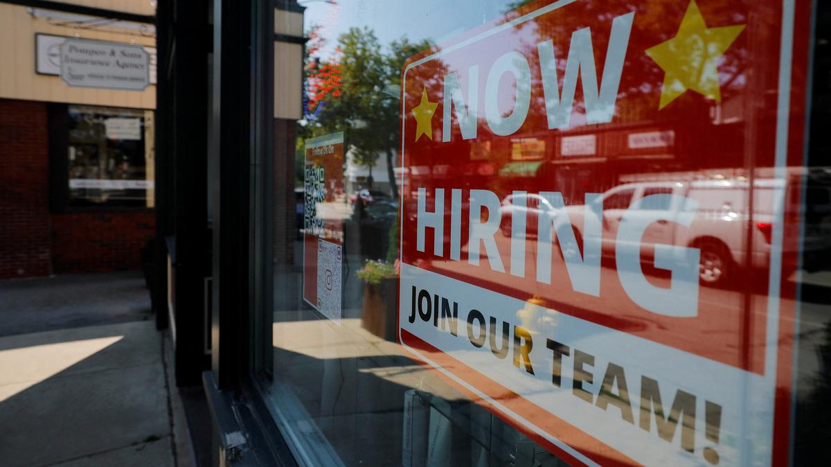 A "Now Hiring" sign hangs in the window of a hair salon in the Greater Boston town of Medford, Massachusetts, U.S., August 12, 2025.   REUTERS/Brian Snyder/File Photo