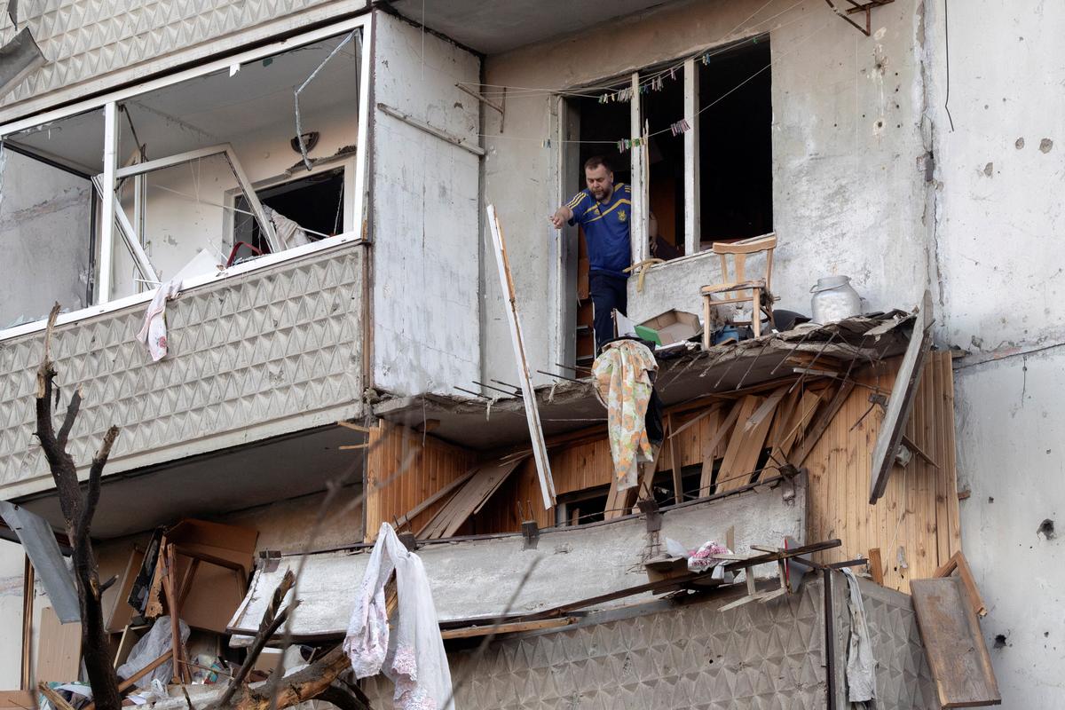 A resident clears debris from his damaged balcony after overnight Russian missile and drone attacks, amid Russia's attack on Ukraine, in Kyiv, Ukraine, June 2, 2026. REUTERS/Thomas Peter