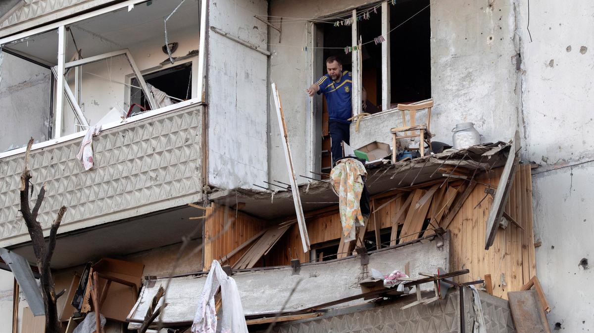 A resident clears debris from his damaged balcony after overnight Russian missile and drone attacks, amid Russia's attack on Ukraine, in Kyiv, Ukraine, June 2, 2026. REUTERS/Thomas Peter
