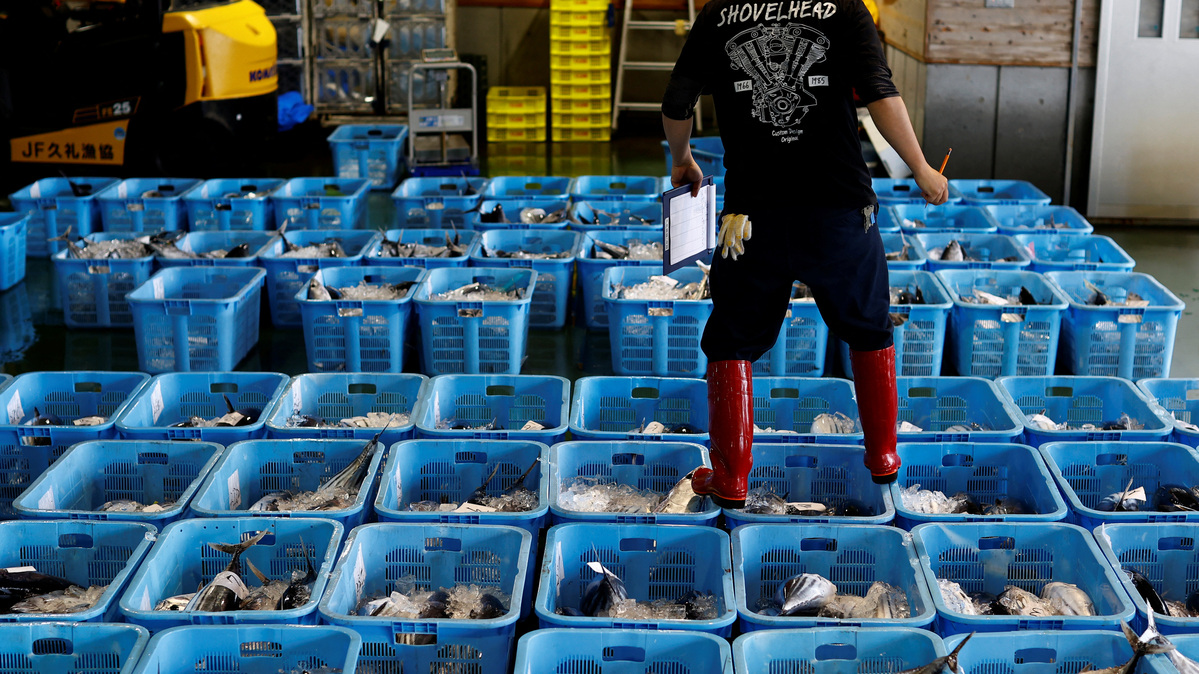 A member of the fish market staff checks the boxes of katsuo (shipjack tuna) before a wholesale auction at Kure Port, in Nakatosa Town, Kochi Prefecture, Japan, May 14, 2022.    REUTERS/Kim Kyung-Hoon