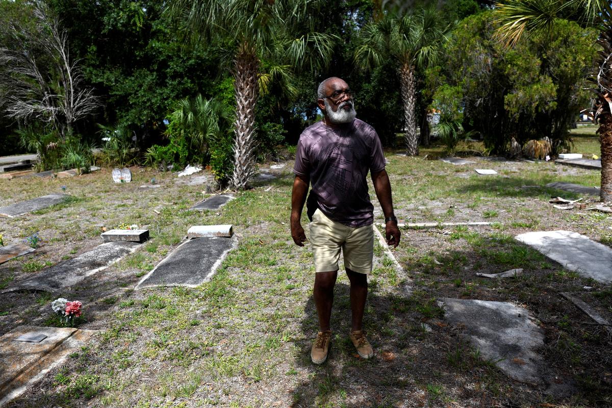 Glenn Searls searches for his mother’s grave at the Old Memphis Cemetery, a predominantly African-American cemetery in Palmetto, to inspect it along with others, after 17 gravesites were vandalized in Palmetto, Florida, U.S., May 14, 2026. Authorities say “Trump” and “DeSantis” were spray-painted in red across multiple tombs as police continue investigating the incident. REUTERS/Octavio Jones