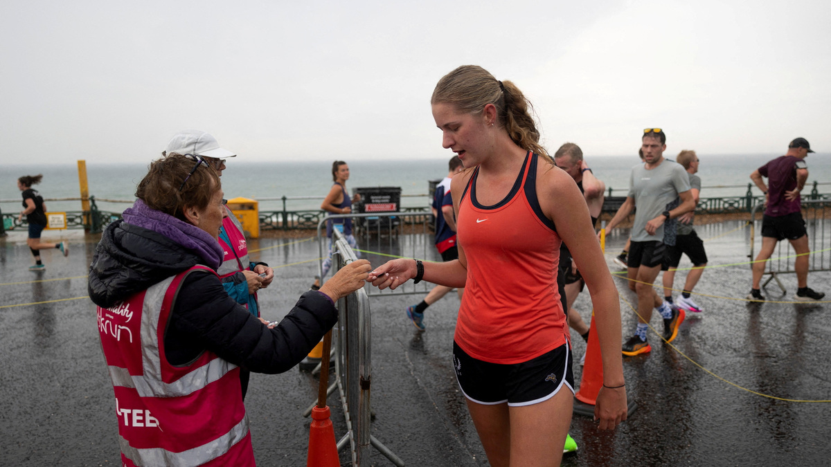 FILE PHOTO: A runner collects her token with a barcode to check her time as she finishes her weekly Saturday 5km run at Hove Promenade parkrun in Brighton, Britain, September 21, 2024. REUTERS/Carlos Jasso/File Photo