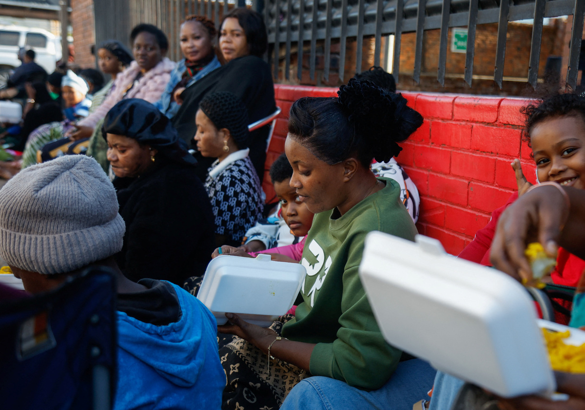 33-year-old Princess Adjei eats a meal on the street where she is staying after her salon was destroyed in a xenophobic attack on May 18, in Durban, South Africa, June 8, 2026. REUTERS/Rogan Ward