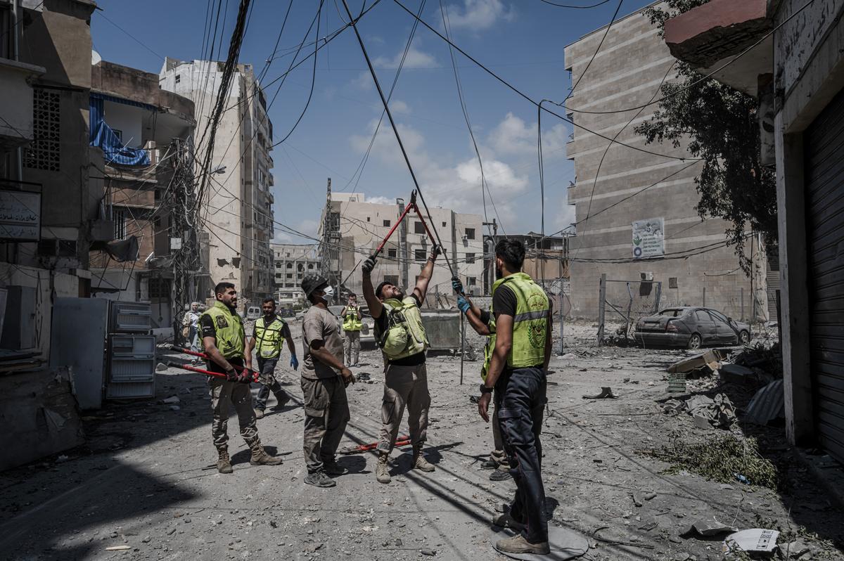 Civil defense workers cut fallen power lines as they clean up amid buildings destroyed in recent Israeli strikes in Tyre, Lebanon, May 29, 2026. (Daniel Berehulak/The New York Times)