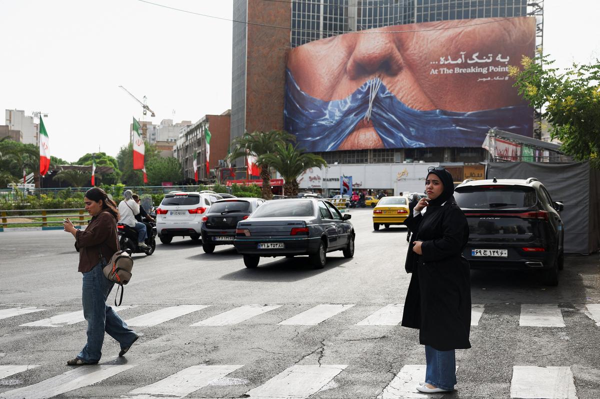 A woman walks past an anti-U.S. billboard depicting U.S. President Donald Trump and the Strait of Hormuz, in Tehran, Iran, May 17, 2026. Majid Asgaripour/WANA (West Asia News Agency) via REUTERS
