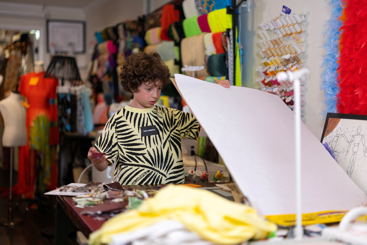 Max Alexander, 10, a fashion designer who recently debuted his first runway show in Paris, works in his studio at his parents' home in Los Angeles, California, U.S., June 5, 2026. REUTERS/Mike Blake