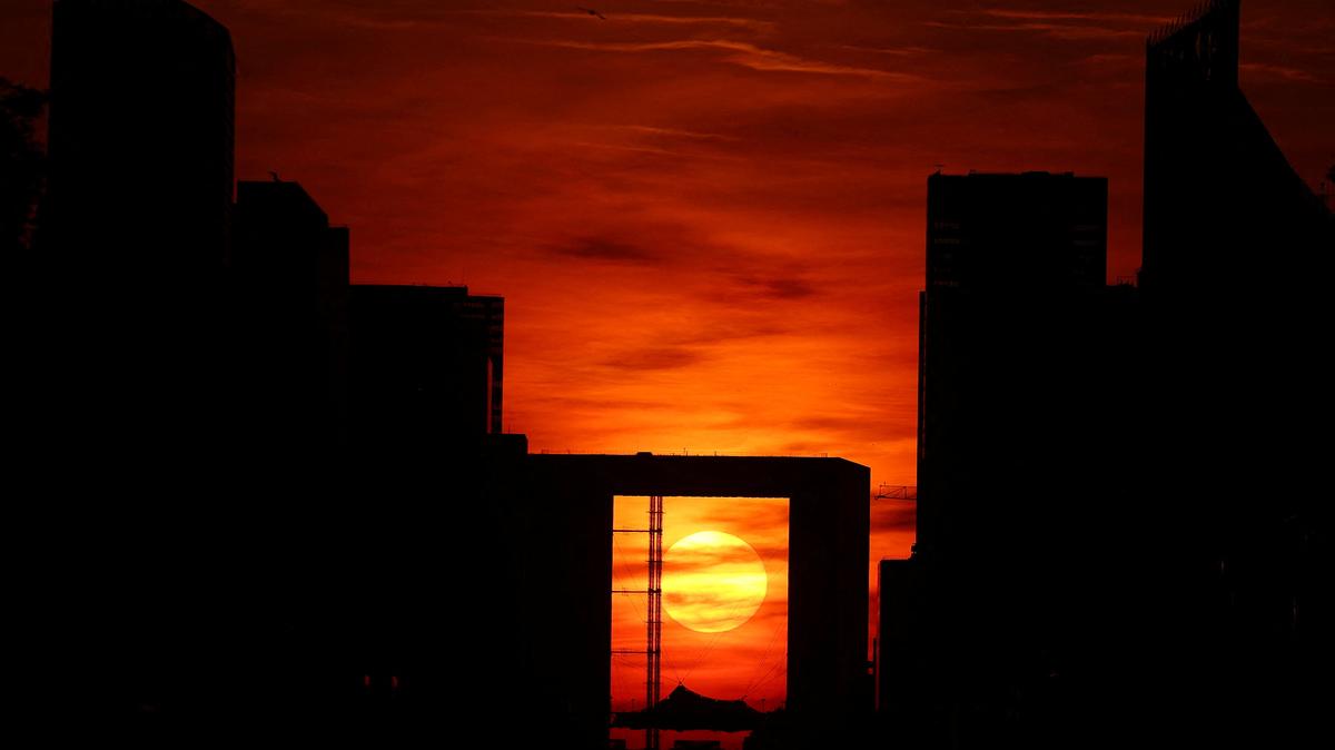 The sun appears in the middle of the Grande Arche at sunset at the financial and business district of La Defense in Puteaux near Paris, France, May 8, 2026. REUTERS/Abdul Saboor