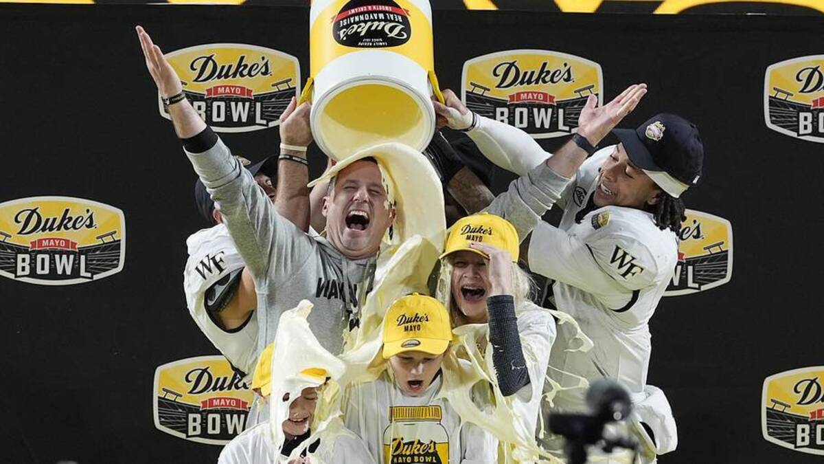  Jan 2, 2026; Charlotte, NC, USA; Wake Forest Demon Deacons defensive back Nick Andersen (45) and Wake Forest Demon Deacons quarterback Robby Ashford (2) dump mayo on head coach Jake Dickert and his family receive the traditional mayo dump after Wake Forest Demon Deacons win at Bank of America Stadium. Mandatory Credit: Jim Dedmon-Imagn Images | Jim Dedmon-Imagn Images 