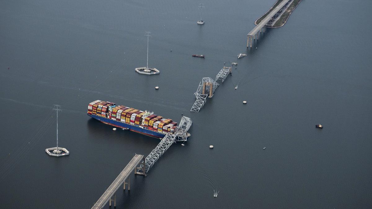 FILE -- An aerial view of the Dali container ship with a collapsed section of the Francis Scott Key Bridge across its bow, in Baltimore on March 26, 2024. Federal prosecutors announced criminal charges on May 12, 2026 against the owner and operator of the Dali, more than two years after the vessel slammed into the Key Bridge, killing six workers and bringing one of the nation's busiest ports to a halt. (Erin Schaff/The New York Times)