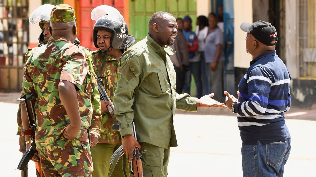 Riot police officers talk to a demonstrator during protests against a U.S.-backed Ebola quarantine plan on the establishment of a 50-bed facility at a Kenyan air force base that was intended to host Americans exposed to Ebola, in Nanyuki town, in Laikipia County, Kenya June 1, 2026. REUTERS/John Muchucha