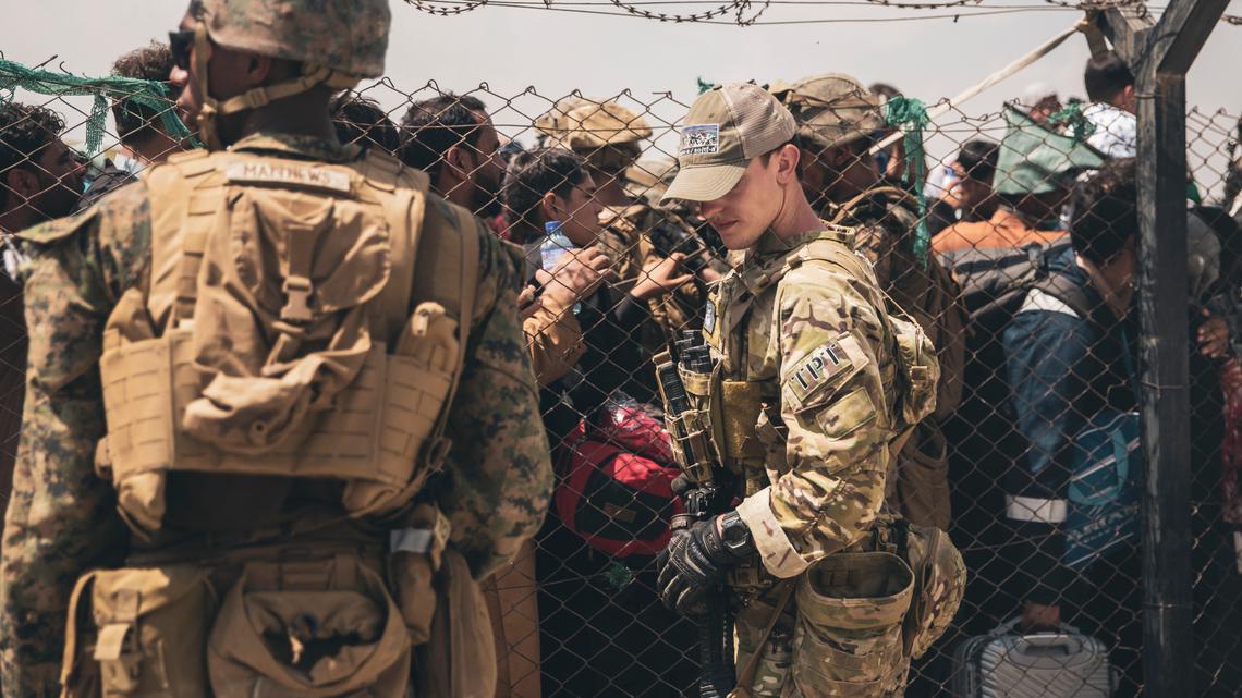 In this Aug. 22, 2021, photo provided by the U.S. Marines, U.S. service members provide assistance during an evacuation at Hamid Karzai International Airport in Kabul, Afghanistan. (Staff Sgt. Victor Mancilla/U.S. Marine Corps via AP)