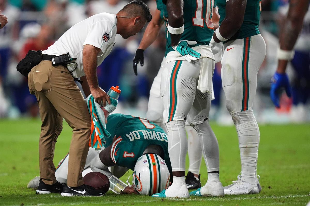  A member of the Miami Dolphins training staff attends to quarterback Tua Tagovailoa (1) after an apparent concussion. Jasen Vinlove-Imagn Images