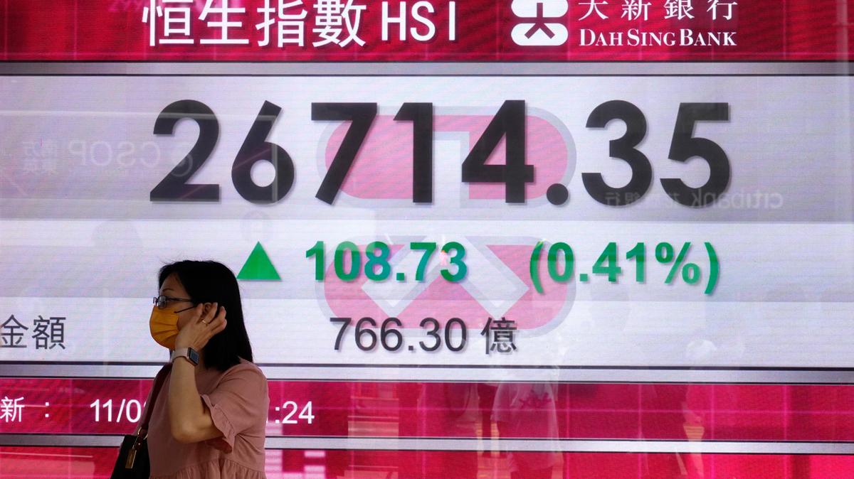 Una mujer camina frente a una pizarra electrónica que muestra el balance de la Bolsa de Valores de Hong Kong, el miércoles 11 de agosto de 2021. De acuerdo con la calificación de 176 territorios que realizó World Population Review en 2019, Singapur y Hong Kong tenían un CI de 108. En términos de inteligencia individual, 108 está en el extremo superior del rango de inteligencia normal de 90 a 109.