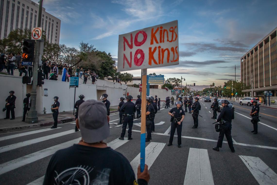  A man holds a sign near the Metropolitan Detention Center to protest immigration enforcement tactics and federal overreach, during a national “No Kings” protest on March 28 in Los Angeles. 