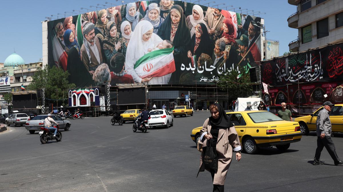 People walk past a billboard with a picture of Iranian people, in Tehran, Iran, May 25, 2026. Majid Asgaripour/WANA (West Asia News Agency) via REUTERS