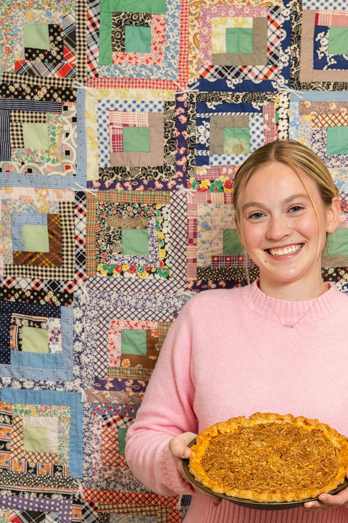 Seraphina Shutt, a freshman, with an apple pie at the Dacie Moses House, Carleton College's cookie house in Northfield, Minn., March 30, 2026. For decades, Carleton College has kept a place where students and others can come, bake and share. (Liam James Doyle/The New York Times)