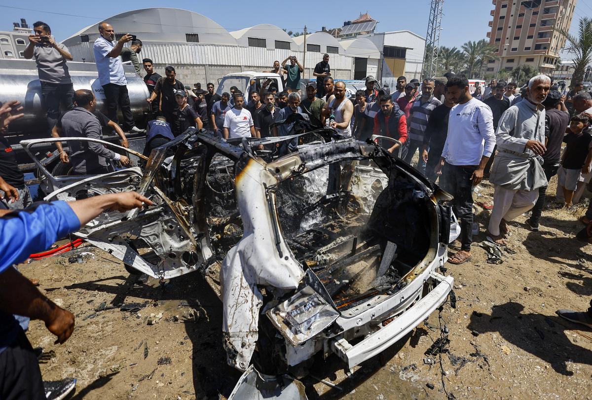 Palestinians inspect a destroyed vehicle at the site of an Israeli strike, in Deir al-Balah, in the central Gaza Strip, June 2, 2026. REUTERS/Mahmoud Issa