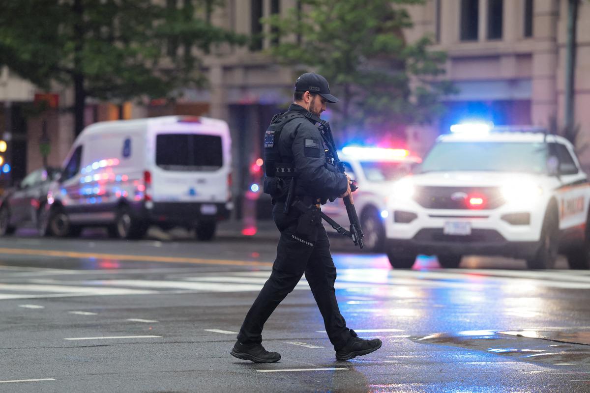 A U.S. Secret Service agent walks with law enforcement vehicles in the background near the White House, after alleged gunshots were heard nearby,  in Washington, D.C., U.S., May 23, 2026. REUTERS/Kylie Cooper