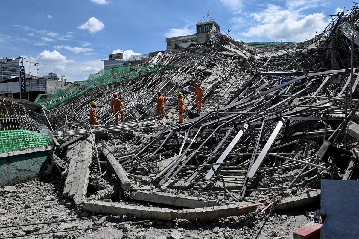 Rescue workers search for survivors among debris as a nine-storey building under construction collapsed in Balibago, Angeles City, Pampanga, Philippines, May 24, 2026. REUTERS/Noel Celis     TPX IMAGES OF THE DAY