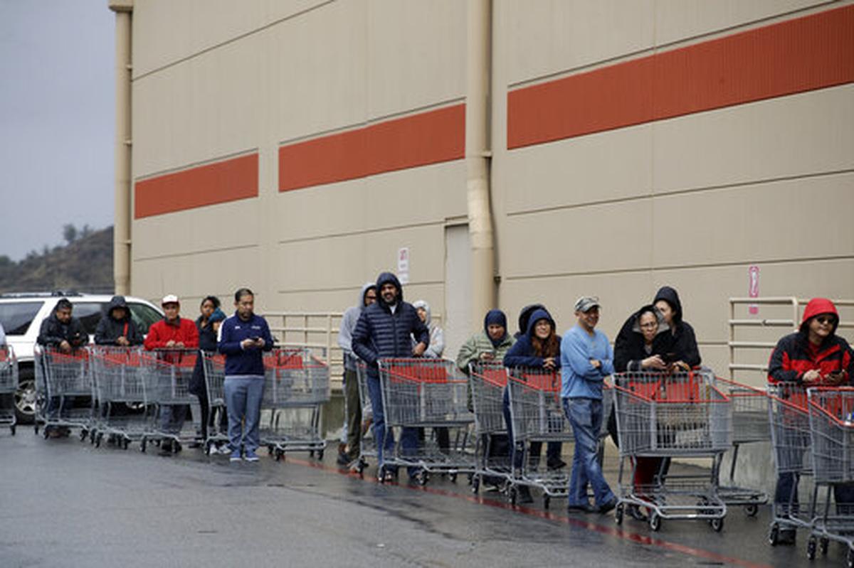 Shoppers wait to enter a Costco warehouse Saturday, March 14, 2020, in Santa Clarita, Calif.