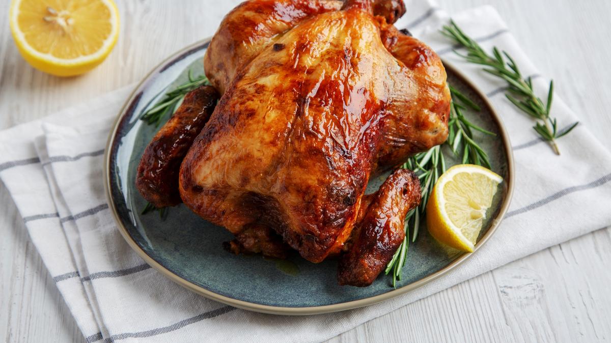 Homemade Lemon and Herb Rotisserie Chicken on a Plate, side view.