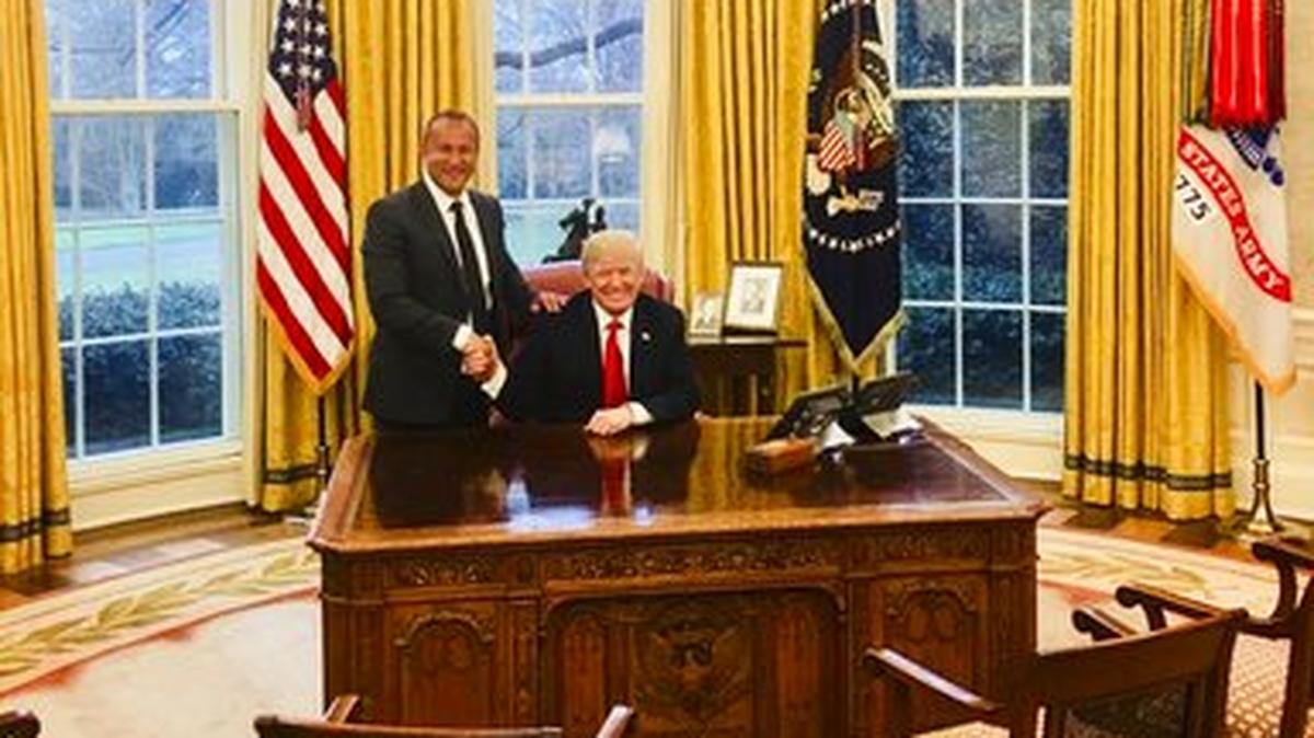 Esta imagen de la página web del presidente ejecutivo de Allied Wallet, Ahmad Khawaja, lo muestra  posando con el presidente Donald Trump en la Oficina Oval de la Casa Blanca en Washington.