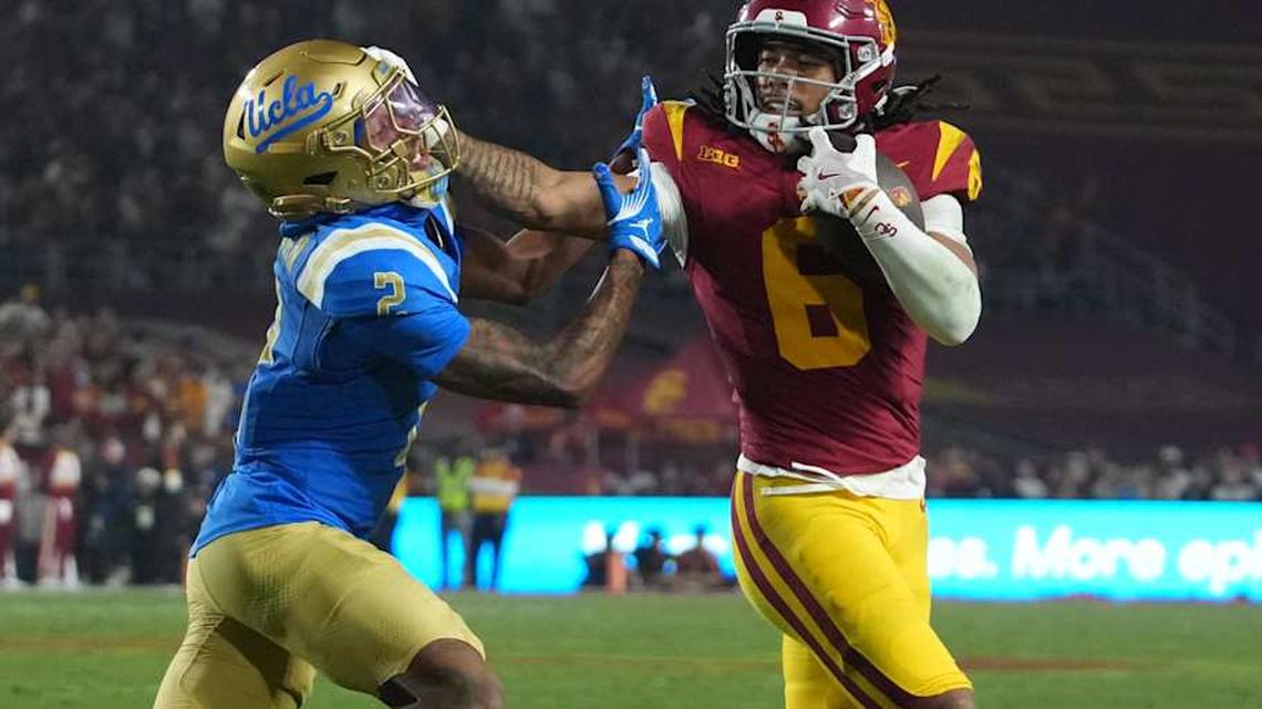  Nov 29, 2025; Los Angeles, California, USA; Southern California Trojans wide receiver Makai Lemon (6) carries the ball against UCLA Bruins defensive back Andre Jordan Jr. (2) in the second half at United Airlines Field at Los Angeles Memorial Coliseum. Mandatory Credit: Kirby Lee-Imagn Images | Kirby Lee-Imagn Images 