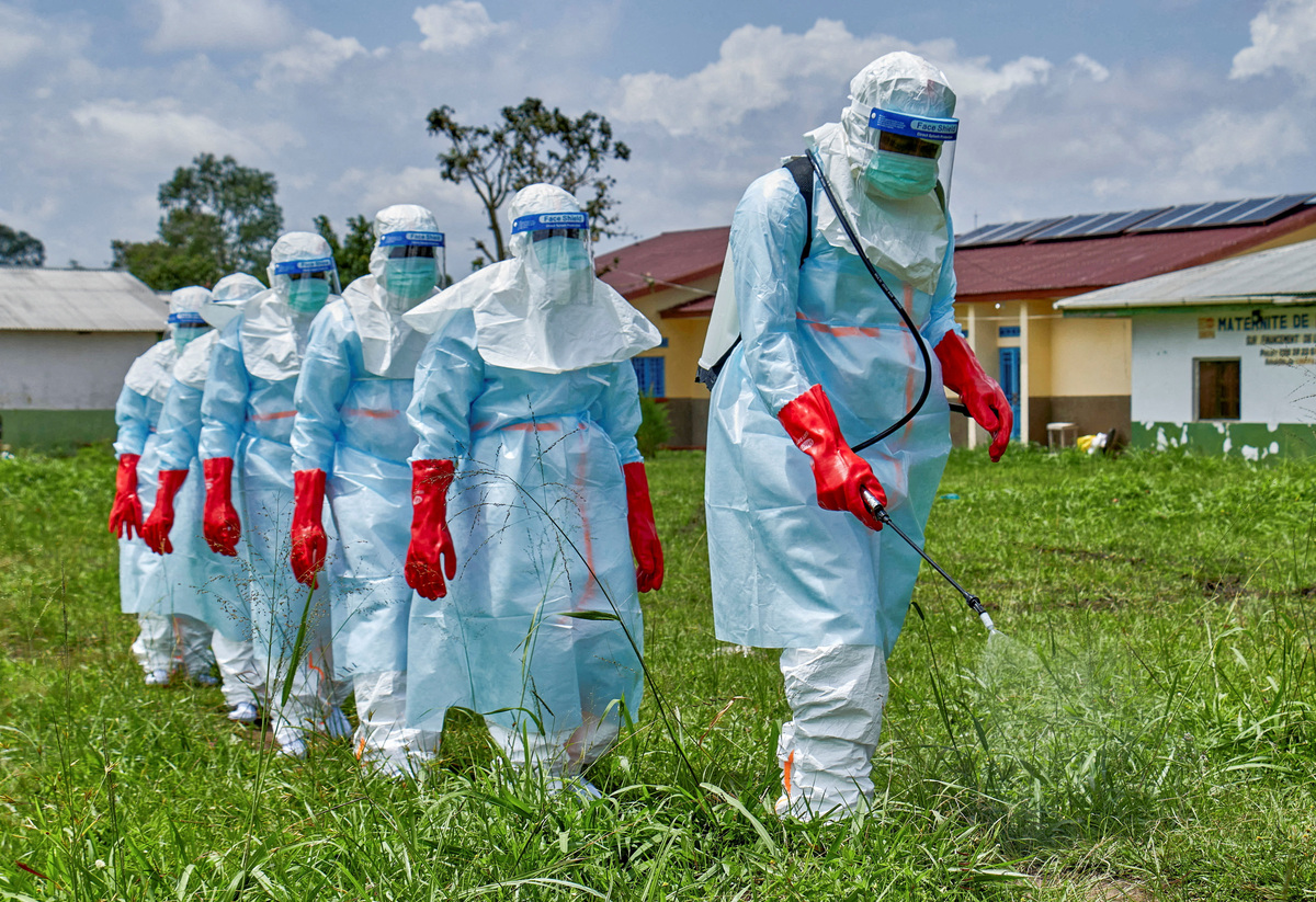 FILE PHOTO: Red Cross workers walk in a formation as they disinfect Rwampara general hospital before handling the body of a person who died of Ebola, as aid agencies intensify efforts to contain a new Ebola outbreak involving the Bundibugyo strain, in Rwampara outside Bunia, Ituri province, Democratic Republic of Congo, May 21, 2026. REUTERS/Gradel Muyisa Mumbere/File Photo