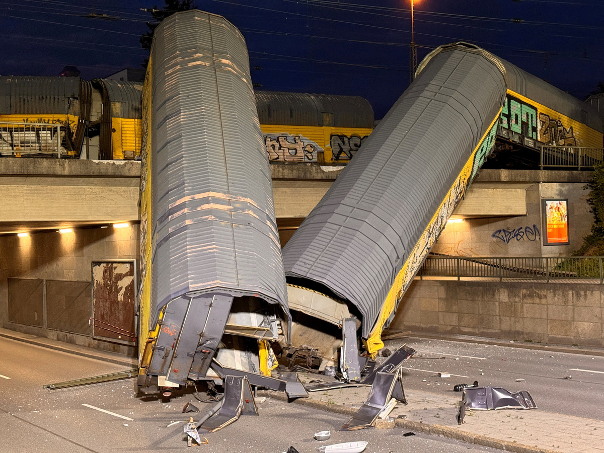 Two cars of a freight train which derailed after a collision, fell off a bridge and lay on a road in Munich, Germany, June 20, 2026.   REUTERS/Christine Uyanik