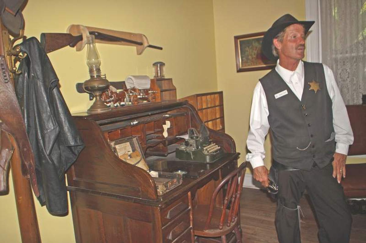  Old Jail guide, "Deputy Clyde," tells about items on the Sheriff’s desk in the section where the sheriff and his family lived. Photo credit: Kathleen Walls 