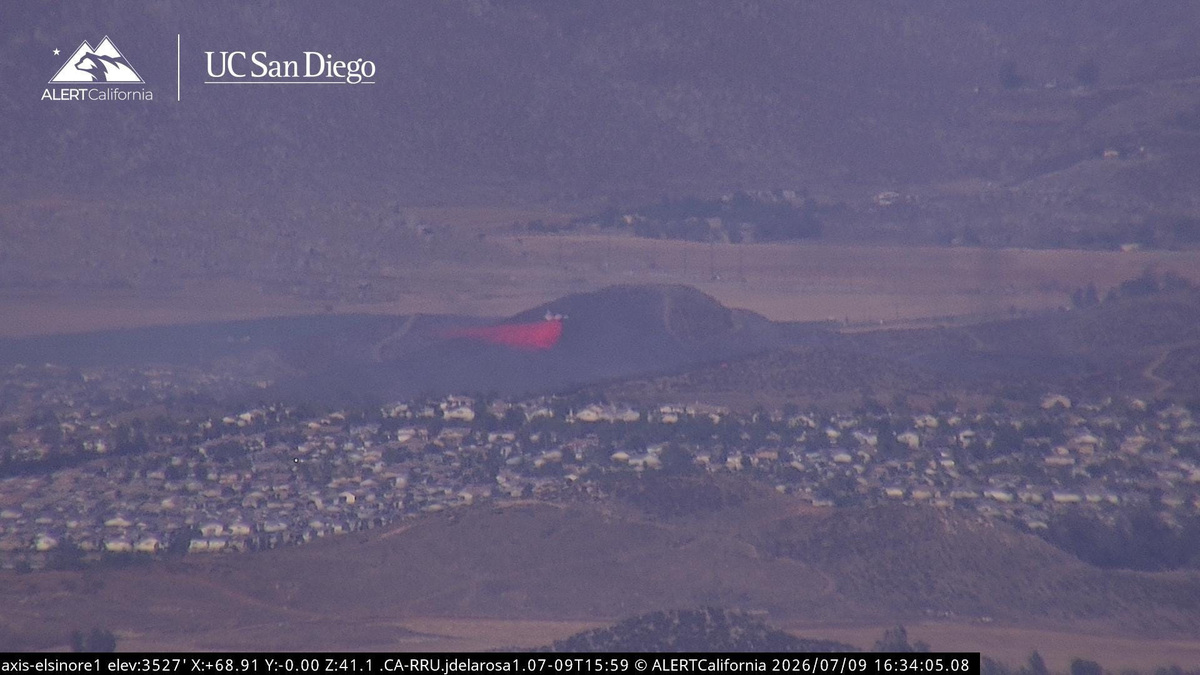 An aircraft drops fire retardant near Bell Mountain as the Bluff Fire burns near homes in Menifee, Calif. on Thursday, July 9, 2026.