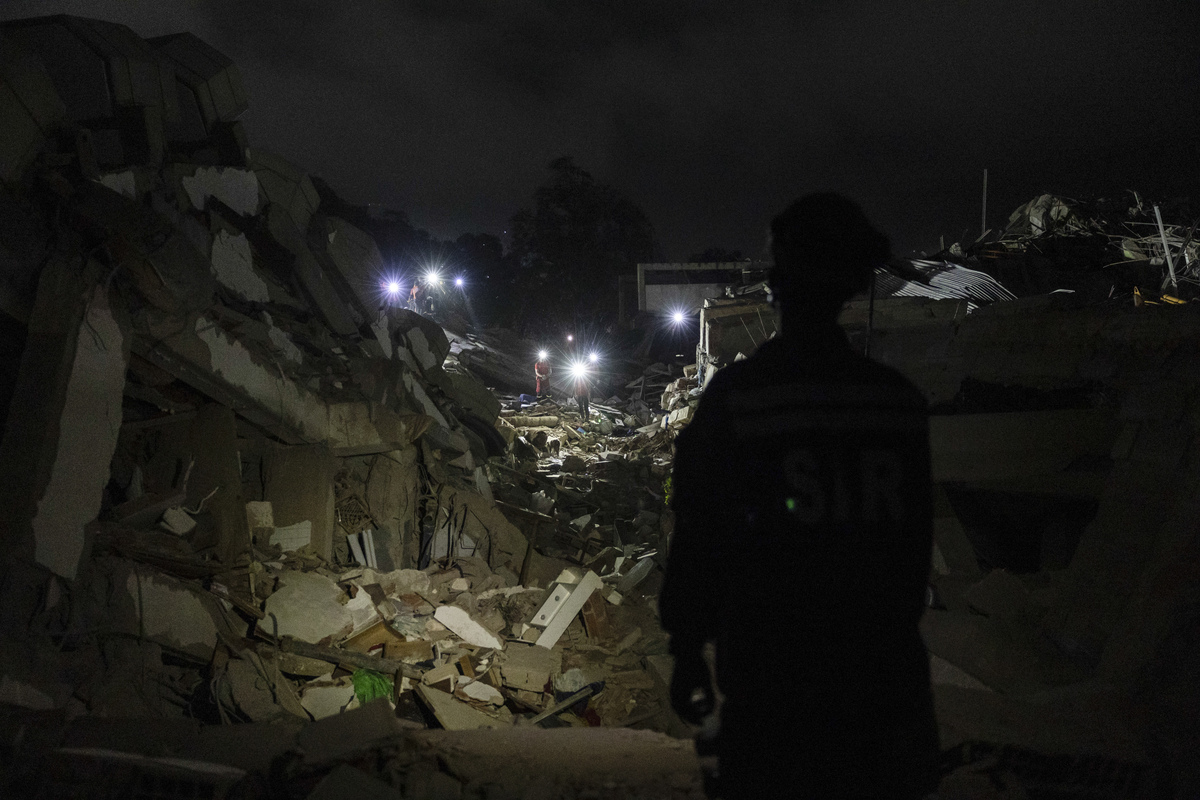 Rescue workers search by headlamps at the Gabarra building that collapsed in last week's earthquakes in La Guaira, Venezuela, on Monday, June 29, 2026. It has been six days since devastating twin earthquakes flattened entire residential neighborhoods in Venezuela, and dozens of new bodies are still being hauled out of the rubble. (Fabiola Ferrero/The New York Times)