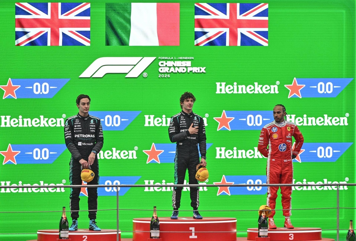  Winner Kimi Antonelli (C), second-placed George Russell (L), and third-placed Lewis Hamilton (R) celebrate on the podium at the 2026 F1 Chinese Grand Prix. HECTOR RETAMAL / AFP via Getty Images