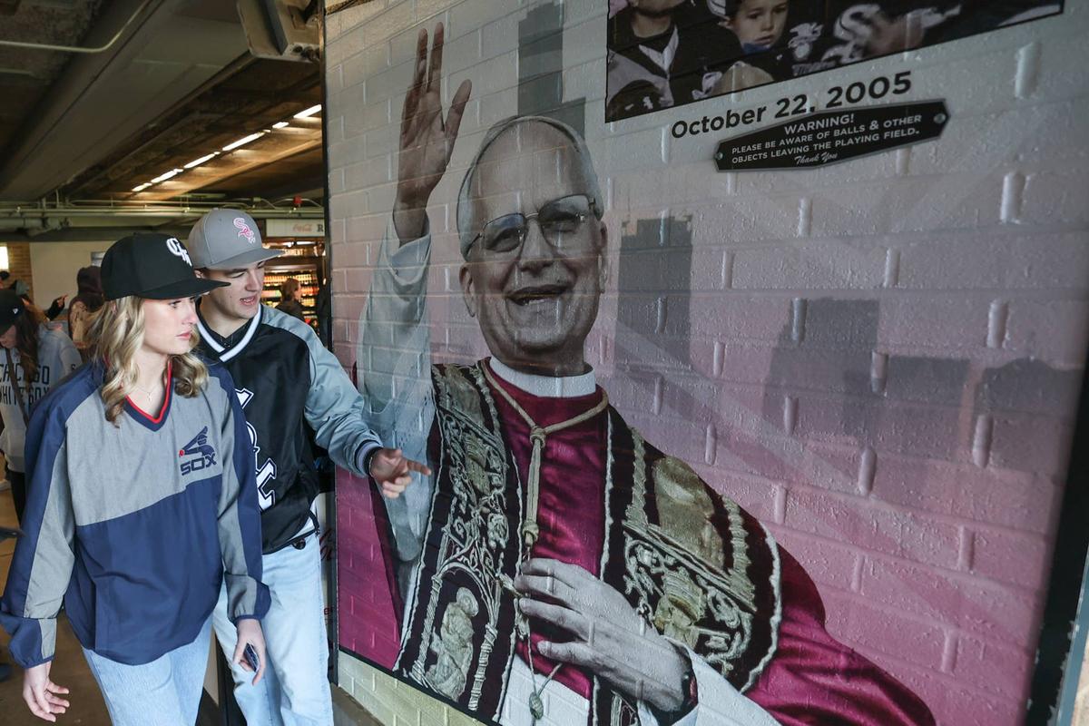  May 23, 2025; Chicago, Illinois, USA; Fans walk by fandom of Pope Leo XIV with graphics before a baseball game between the Chicago White Sox and Texas Rangers at Rate Field. Mandatory Credit: Kamil Krzaczynski-Imagn Images 