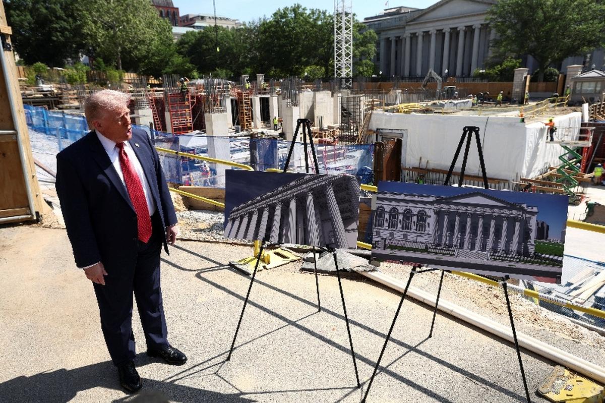U..S. President Donald Trump shows images of the concept at the site of ongoing construction of the planned White House ballroom in Washington, D.C., U.S., May 19, 2026. REUTERS/Kevin Lamarque