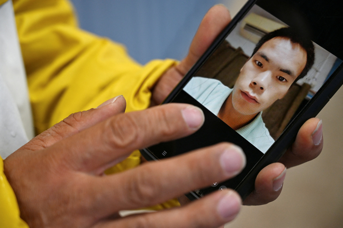 Yanfeng Ge shows a picture of his brother, Chaofeng Ge, who was found dead in ICE custody in 2025, in Dickens, Texas, U.S. May 26, 2026.  REUTERS/Annie Rice