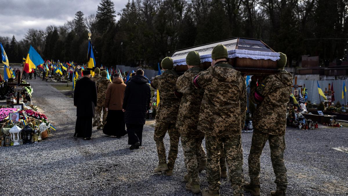 Military servicemen carry the coffin of a 20-year-old soldier at a cemetery in Lviv, western Ukraine, on Feb. 22.