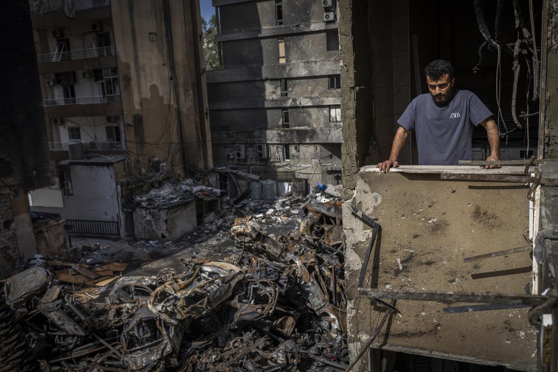A man looks out from his apartment over the wreckage in his neighborhood near the Corniche, the seaside promenade, in Beirut, Lebanon, on Monday, April 13, 2026. According to the Lebanese government, more than 2,000 people have been killed in the country since the Iran-backed militia Hezbollah fired on northern Israel in early March, prompting a widening Israeli ground invasion. (Diego Ibarra Sánchez/The New York Times)