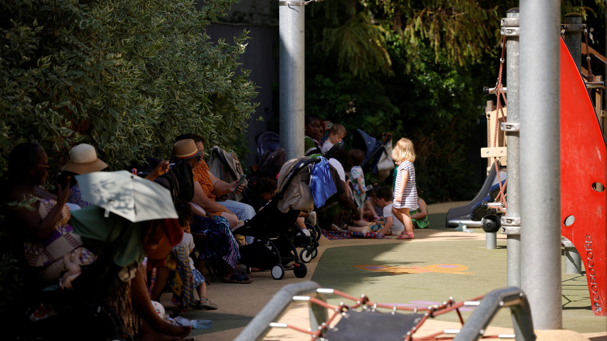 Parents and young children shelter in the shade at a children's playground in Paris as temperatures rise during a heatwave affecting a large part of France, June 22, 2026. REUTERS/Alice Sacco