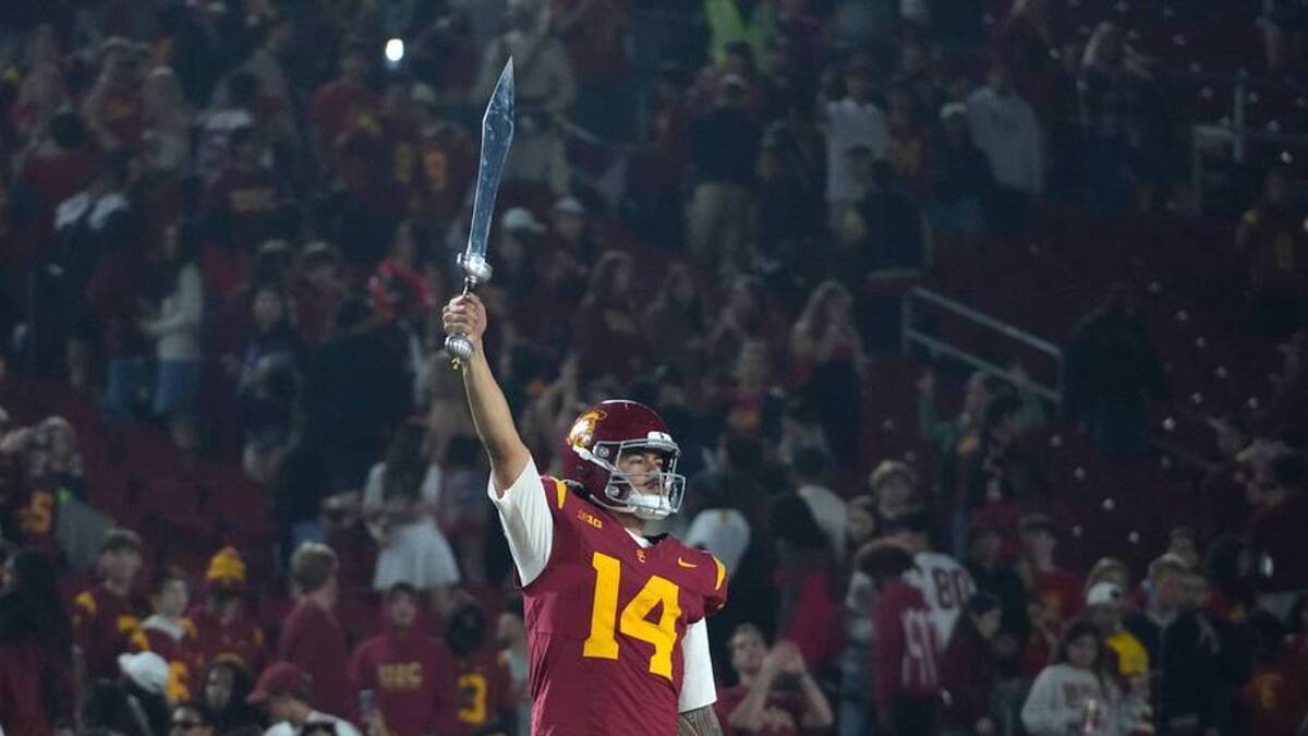  Nov 29, 2025; Los Angeles, California, USA; Southern California Trojans quarterback Jayden Maiava (14) leads the Spirit of Troy marching band in a rendition of Tribute to Troy after teh game against the UCLA Bruins at United Airlines Field at Los Angeles Memorial Coliseum. Mandatory Credit: Kirby Lee-Imagn Images | Kirby Lee-Imagn Images 