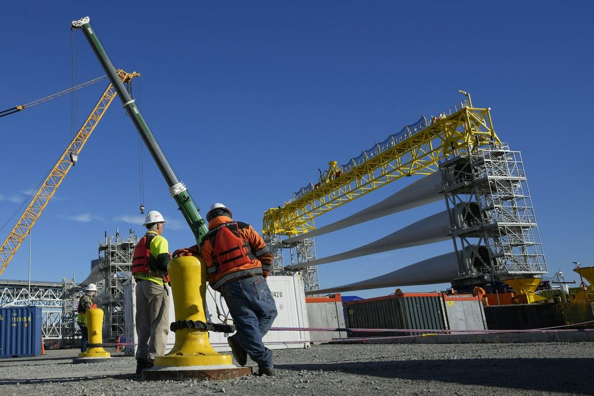  Workers in New London, Conn., prepare a generator and its blades for transport to South Fork Wind's offshore wind farm in 2023. To build an offshore wind farm requires manufacturing jobs, parts suppliers, dockworkers, crane operators, ship crews, as well as the wind farm construction crews and maintenance teams and many more businesses and their employees. AP Photo/Seth Wenig 