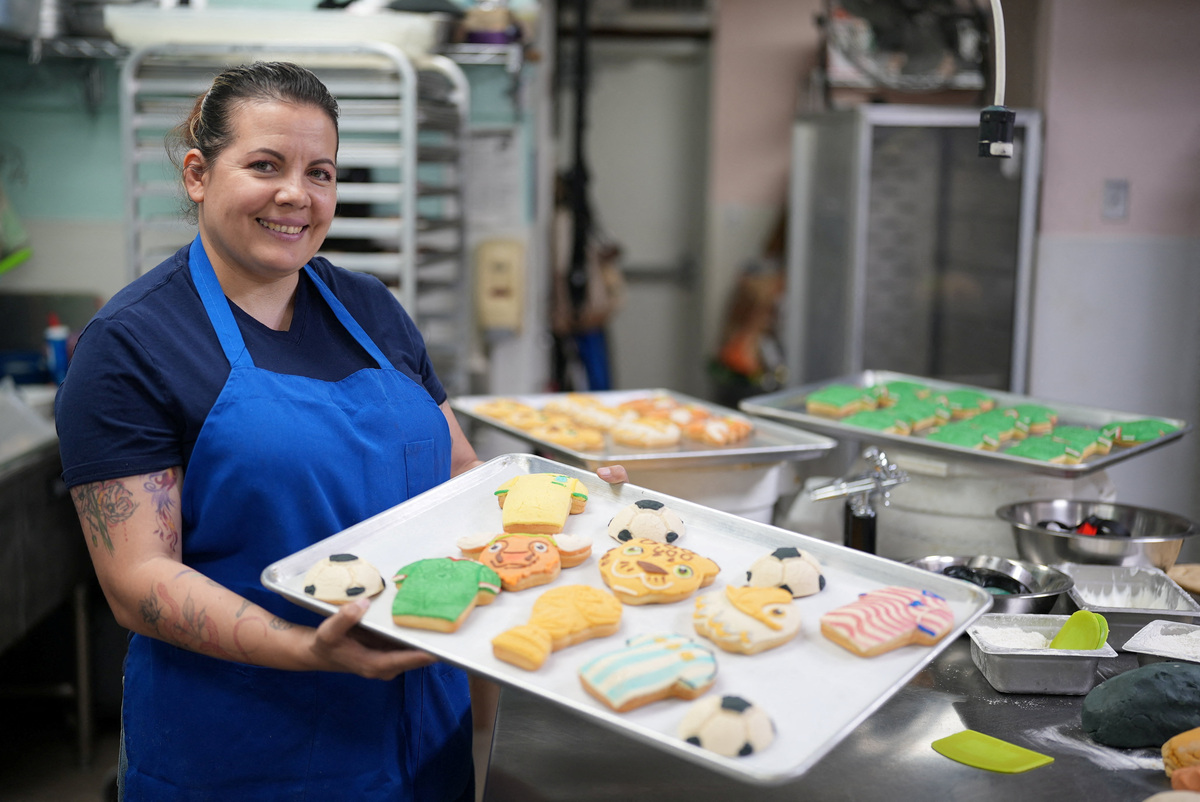Erika Lopez, 42, owner of the Cookieteria by Lovely bakery, poses for a photograph holding a tray of 2026 World Cup-themed conchas, traditional Mexican sweet breads, at the Cookieteria by Lovely bakery, in West Covina, California, U.S., June 20, 2026. REUTERS/Leonardo Benassatto