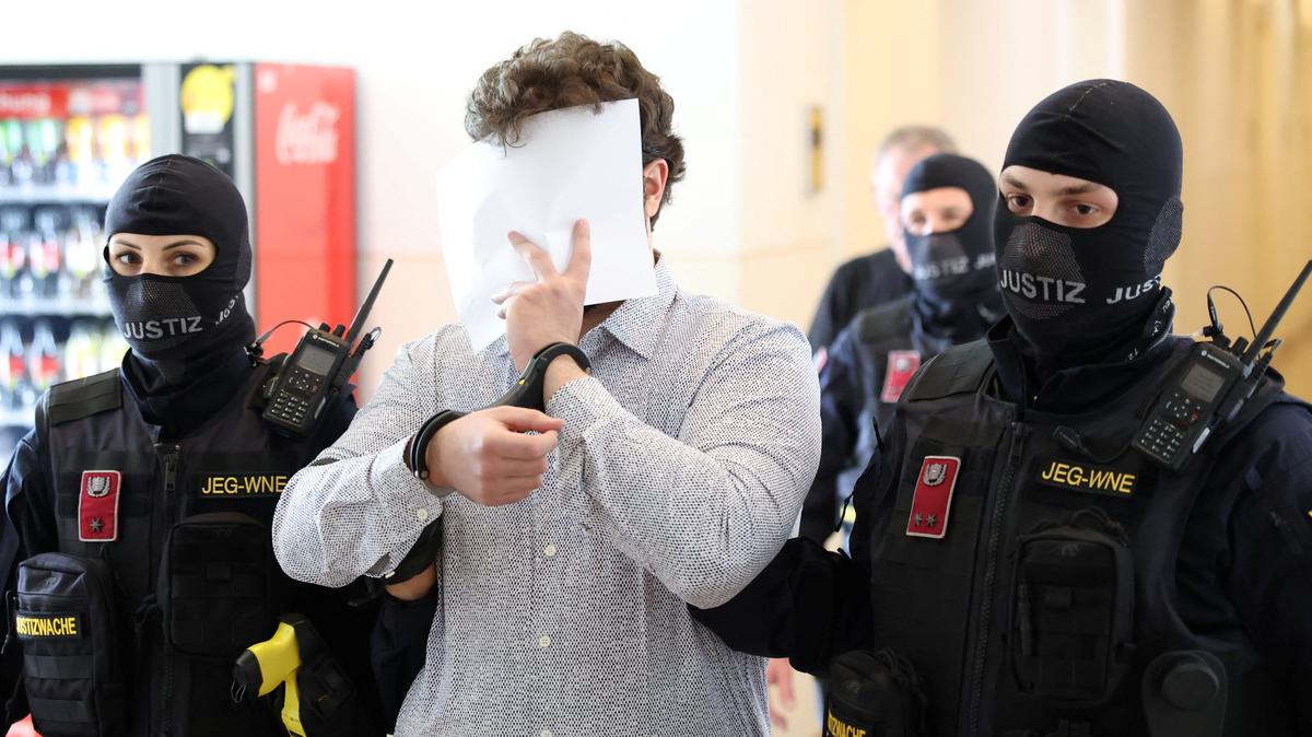 The defendant, an Austrian identified as Beran A, one of the men suspected of planning an attack on Taylor Swift's Vienna concert in 2024, is escorted by security personnel during a break in a courtroom for his trial in Wiener Neustadt, Austria, April 28, 2026.REUTERS/Leonhard Foeger