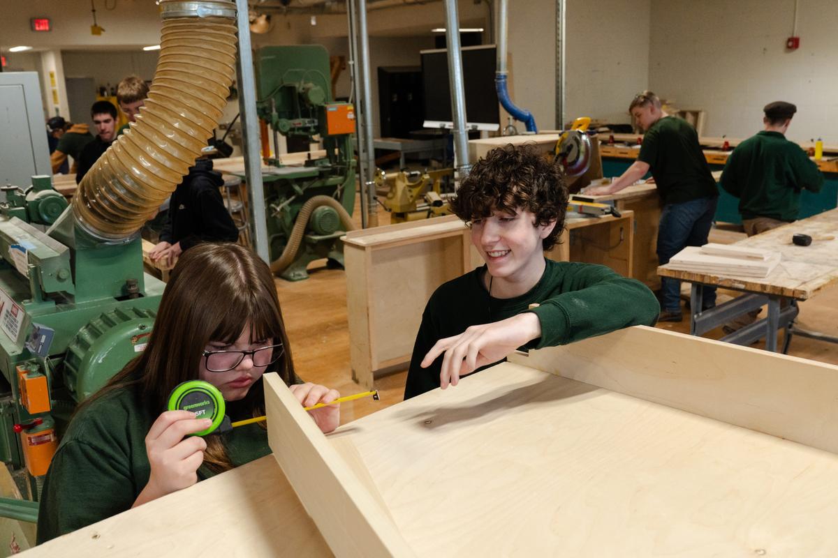  Ivy Wentzel, 15, one of two girls in her carpentry class, takes measurements for a cabinet project with Trevin Rowland, 17, in their carpentry shop at Harvard H. Ellis Technical School in Danielson, CT on April 7, 2026. While a couple of the other trades taught at Ellis Tech skew female - hairdressing and health care technology, in particular - Ellis Tech's overall enrollment is 70 percent male. Statewide, more than 60 percent of the roughly 11,000 students attending technical high schools are boys. Credit: Sophie Park for The Hechinger Report